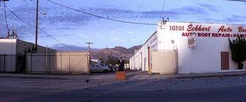 Movie still from “Punch-Drunk Love” (2002), directed by Paul Thomas Anderson – A man standing on a box in the middle of a street; Extreme Wide shot, High angle
