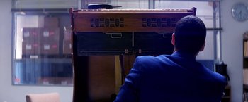 Movie still from “Punch-Drunk Love” (2002), directed by Paul Thomas Anderson – A man sitting in front of an old piano; Medium shot, Low angle
