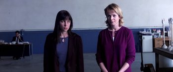 Movie still from “Punch-Drunk Love” (2002), directed by Paul Thomas Anderson – Two women standing next to each other in front of a wall; Medium shot, Low angle