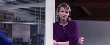 Movie still from “Punch-Drunk Love” (2002), directed by Paul Thomas Anderson – A woman standing in front of a window with her arms crossed; Close Up shot, Low angle