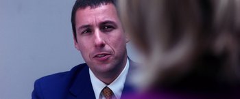Movie still from “Punch-Drunk Love” (2002), directed by Paul Thomas Anderson – A person wearing a suit and tie; Close Up shot, Over the shoulder angle