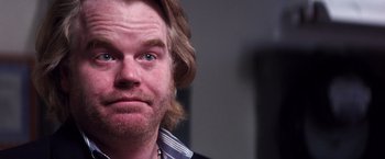 Movie still from “Punch-Drunk Love” (2002), directed by Paul Thomas Anderson – A person with long hair and a beard; Close Up shot, Over the shoulder angle