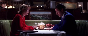 Movie still from “Punch-Drunk Love” (2002), directed by Paul Thomas Anderson – A man and a woman sitting at a table; Medium shot, High angle