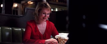 Movie still from “Punch-Drunk Love” (2002), directed by Paul Thomas Anderson – A woman sitting at a table looking at a basket; Close Up shot, Low angle