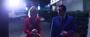 Movie still from “Punch-Drunk Love” (2002), directed by Paul Thomas Anderson – A man and a woman walking down a street at night; Medium shot, Over the shoulder angle