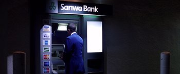Movie still from “Punch-Drunk Love” (2002), directed by Paul Thomas Anderson – A man standing in front of an atm machine; Wide shot, Low angle