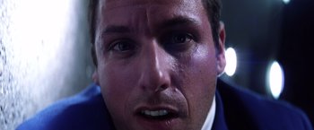 Movie still from “Punch-Drunk Love” (2002), directed by Paul Thomas Anderson – A man's face with a black eye; Extreme Close Up shot, Low angle