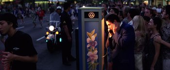 Movie still from “Punch-Drunk Love” (2002), directed by Paul Thomas Anderson – A man on a cell phone next to a phone booth; Medium shot, Low angle