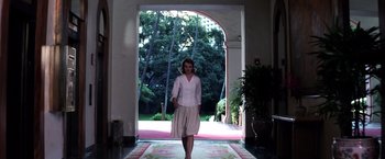 Movie still from “Punch-Drunk Love” (2002), directed by Paul Thomas Anderson – A woman in a white shirt is walking through a doorway; Wide shot, Low angle