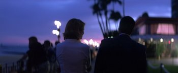 Movie still from “Punch-Drunk Love” (2002), directed by Paul Thomas Anderson – Two people standing in front of lights at night; Medium shot, Over the shoulder angle