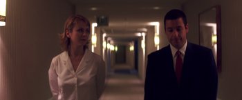 Movie still from “Punch-Drunk Love” (2002), directed by Paul Thomas Anderson – A man and a woman standing in a hotel hallway; Medium shot, Low angle