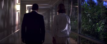 Movie still from “Punch-Drunk Love” (2002), directed by Paul Thomas Anderson – Two people walking down a hallway at night; Medium shot, Low angle