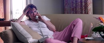 Movie still from “Punch-Drunk Love” (2002), directed by Paul Thomas Anderson – A woman sitting on a couch talking on the phone; Medium shot, Low angle