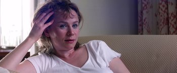 Movie still from “Punch-Drunk Love” (2002), directed by Paul Thomas Anderson – A person sitting on a couch; Close Up shot, Over the shoulder angle