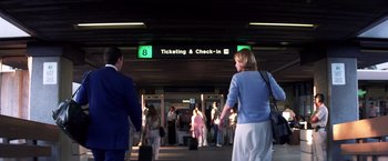 Movie still from “Punch-Drunk Love” (2002), directed by Paul Thomas Anderson – A group of people standing in a train station; Wide shot, Low angle
