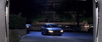 Movie still from “Punch-Drunk Love” (2002), directed by Paul Thomas Anderson – A car parked on the side of the road at night; Wide shot, High angle