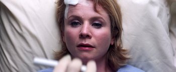 Movie still from “Punch-Drunk Love” (2002), directed by Paul Thomas Anderson – A woman with bandages on her head is laying in a bed; Close Up shot, Overhead angle