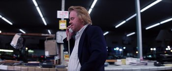 Movie still from “Punch-Drunk Love” (2002), directed by Paul Thomas Anderson – A man talking on a phone while wearing a suit; Medium shot, Low angle