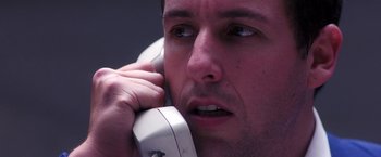 Movie still from “Punch-Drunk Love” (2002), directed by Paul Thomas Anderson – A person talking on a phone; Close Up shot, High angle