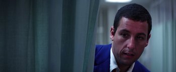 Movie still from “Punch-Drunk Love” (2002), directed by Paul Thomas Anderson – A person wearing a suit and tie; Close Up shot, Low angle