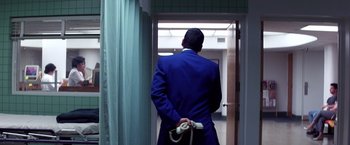 Movie still from “Punch-Drunk Love” (2002), directed by Paul Thomas Anderson – A man in a blue suit is holding a phone; Medium shot, Low angle