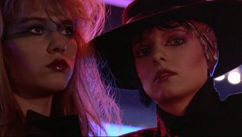 Movie still from “Purple Rain” (1984), directed by Albert Magnoli – Two women in black and red outfits and a black hat; Close Up shot, Low angle