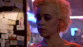 Movie still from “Purple Rain” (1984), directed by Albert Magnoli – A person with pink hair; Close Up shot, Over the shoulder angle