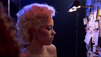 Movie still from “Purple Rain” (1984), directed by Albert Magnoli – A beautiful woman with blonde curly hair and pink lighting; Close Up shot, Low angle