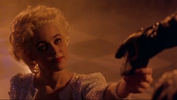 Movie still from “Purple Rain” (1984), directed by Albert Magnoli – A woman in a white dress holding a white dog; Close Up shot, Over the shoulder angle
