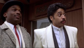 Movie still from “Purple Rain” (1984), directed by Albert Magnoli – A couple of men standing next to each other in suits; Close Up shot, Low angle