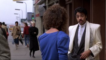 Movie still from “Purple Rain” (1984), directed by Albert Magnoli – A man and a woman standing next to each other on the sidewalk; Medium shot, Over the shoulder angle