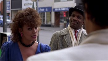 Movie still from “Purple Rain” (1984), directed by Albert Magnoli – A man and a woman standing next to each other on the street; Close Up shot, Over the shoulder angle