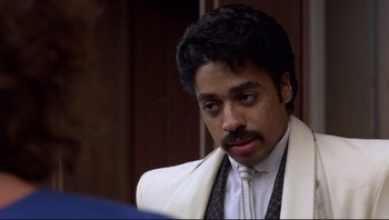 Movie still from “Purple Rain” (1984), directed by Albert Magnoli – A person wearing a suit and tie; Close Up shot, Low angle