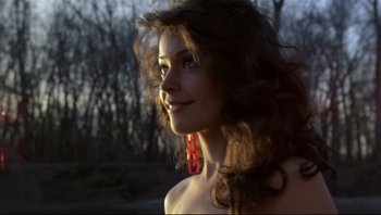 Movie still from “Purple Rain” (1984), directed by Albert Magnoli – A beautiful woman with long curly brown hair wearing red earrings; Close Up shot, Low angle