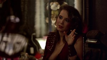 Movie still from “Purple Rain” (1984), directed by Albert Magnoli – A woman smoking a cigarette while wearing a red jacket; Close Up shot, Over the shoulder angle