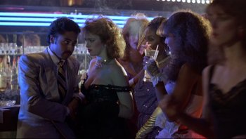Movie still from “Purple Rain” (1984), directed by Albert Magnoli – A group of people standing around each other at a party; Medium shot, Low angle