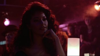 Movie still from “Purple Rain” (1984), directed by Albert Magnoli – A woman with long red curly hair posing for the camera; Close Up shot, Over the shoulder angle