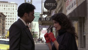 Movie still from “Purple Rain” (1984), directed by Albert Magnoli – A man and a woman standing next to each other on the street; Medium shot, Over the shoulder angle