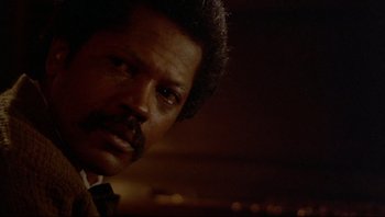 Movie still from “Purple Rain” (1984), directed by Albert Magnoli – A person wearing a suit and tie; Close Up shot, Low angle