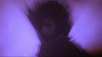 Movie still from “Purple Rain” (1984), directed by Albert Magnoli – A person wearing a purple shirt; Medium shot, Low angle