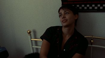 Movie still from “Pusher” (1996), directed by Nicolas Winding Refn – A woman sitting in a chair looking up at the ceiling; Close Up shot, High angle