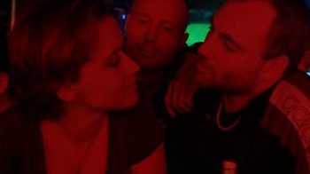 Movie still from “Pusher” (1996), directed by Nicolas Winding Refn – A group of people standing next to each other in a room; Close Up shot, Over the shoulder angle