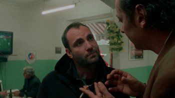 Movie still from “Pusher” (1996), directed by Nicolas Winding Refn – A man looking at himself in the mirror; Close Up shot, Over the shoulder angle