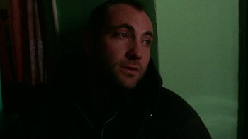 Movie still from “Pusher” (1996), directed by Nicolas Winding Refn – A person wearing a hooded jacket; Close Up shot, Low angle