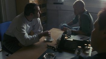 Movie still from “Pusher” (1996), directed by Nicolas Winding Refn – Two men sitting at a table having a conversation; Medium shot, Over the shoulder angle