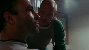 Movie still from “Pusher” (1996), directed by Nicolas Winding Refn – Two men looking into each other's eyes in a room; Close Up shot, Low angle