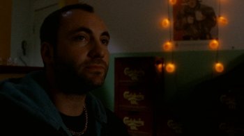 Movie still from “Pusher” (1996), directed by Nicolas Winding Refn – A person wearing a necklace; Close Up shot, Low angle