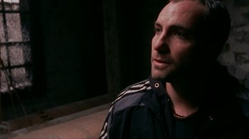 Movie still from “Pusher” (1996), directed by Nicolas Winding Refn – A person wearing a jacket; Close Up shot, Over the shoulder angle
