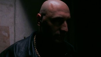 Movie still from “Pusher” (1996), directed by Nicolas Winding Refn – A man with a bald head wearing a leather jacket; Close Up shot, Low angle