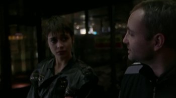 Movie still from “Pusher” (1996), directed by Nicolas Winding Refn – A man and a woman talking to each other in a dark room; Close Up shot, Over the shoulder angle